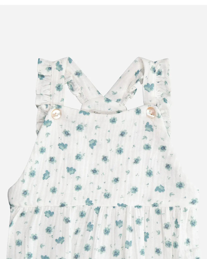 Zoom de la salopette pour bébé fille courte blanche à fleurs vert amande en gaze de coton de la marque Bobine Paris.