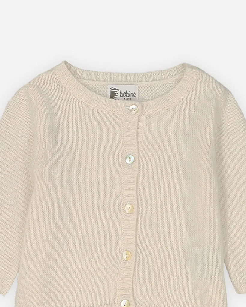 Zoom du cardigan à col rond pour bébé en laine beige sable de la marque Bobine Paris.