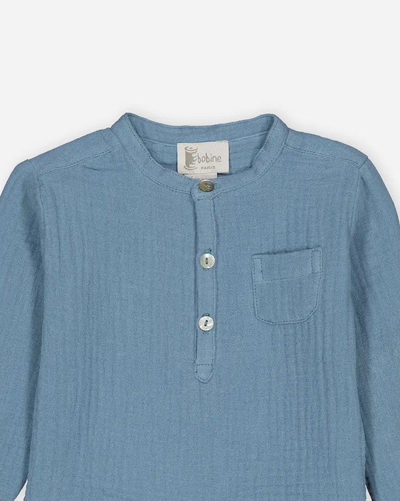 Zoom sur la chemise bébé à col mao en gaze de coton couleur bleu jean clair de la marque Bobine Paris.