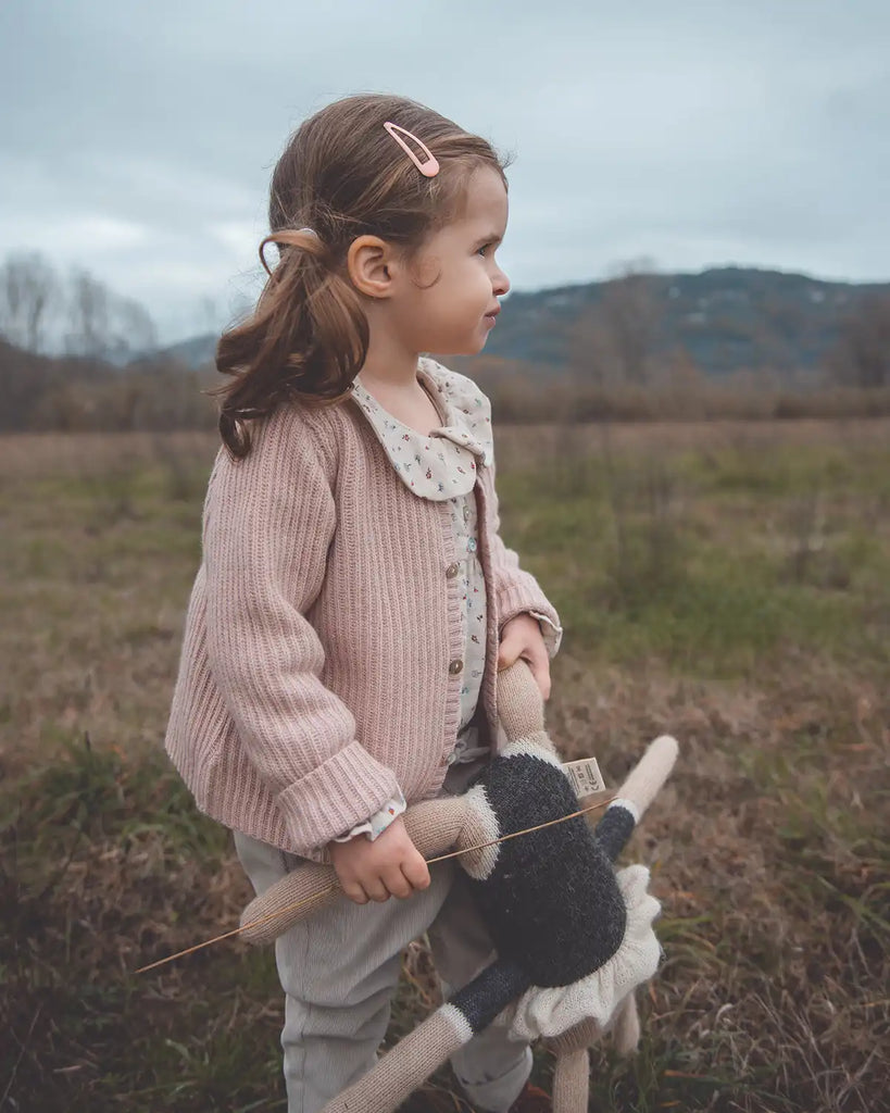 image d'une petite fille portant le cardigan bébé à col rond en laine et cachemire rose poudre Bobine Paris