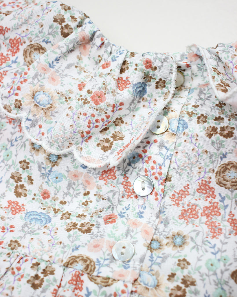 Zoom de la blouse pour bébé fille à col volanté et à fleurs colorées de la marque Bobine Paris.