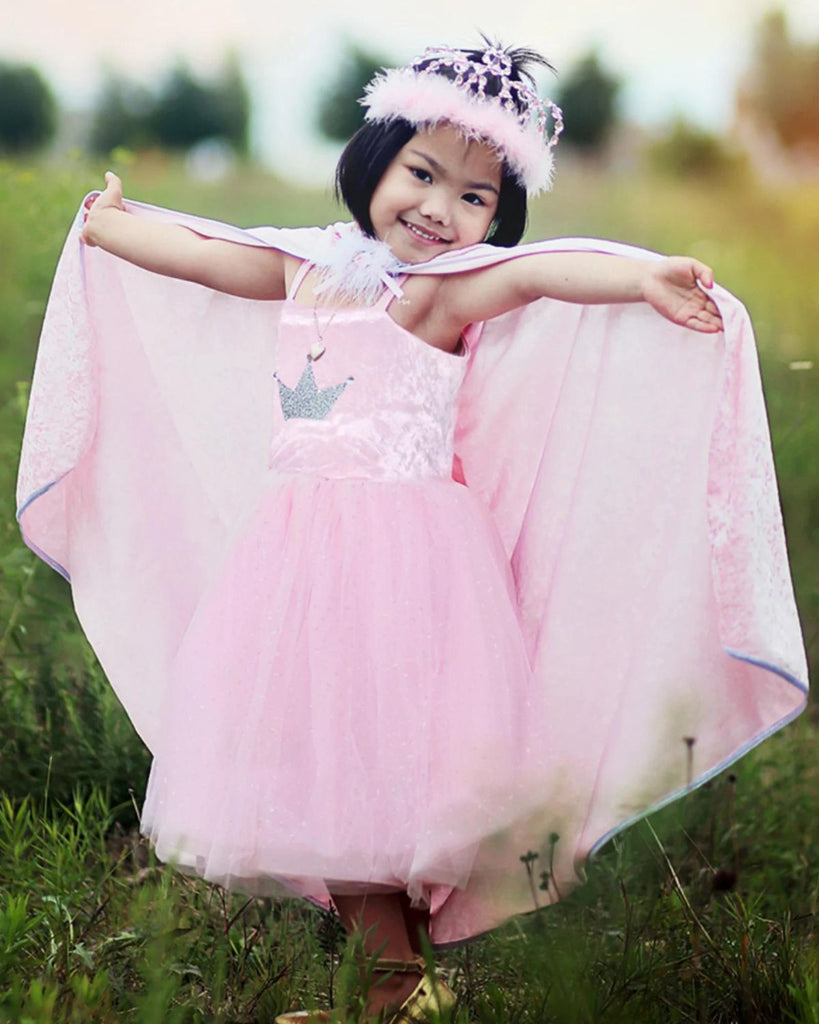 petite fille portant une robe de princesse en velours rose avec un diadème et une cape assortis
