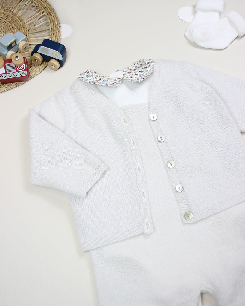 Body bébé blanc à col pointu à imprimé petites voitures porté avec un cardigan écru de la marque Bobine Paris.