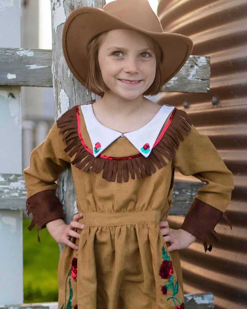 Petite fille portant un chapeau de cowboy et une robe de cowgirl marron avec bords en frange