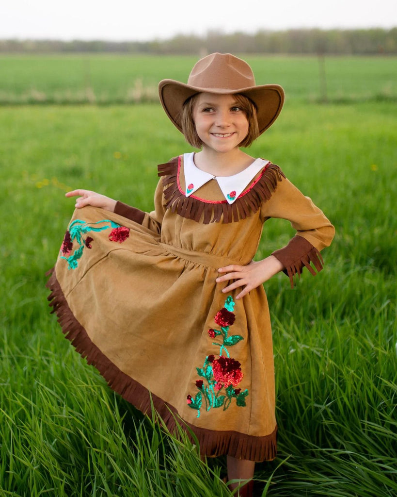 Petite fille portant un chapeau de cowboy et une robe de cowgirl marron avec bords en frange