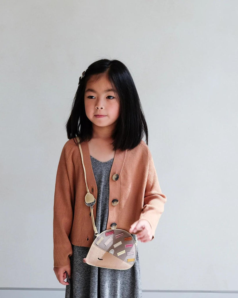Petite fille portant un sac bandoulière en forme d'hérisson