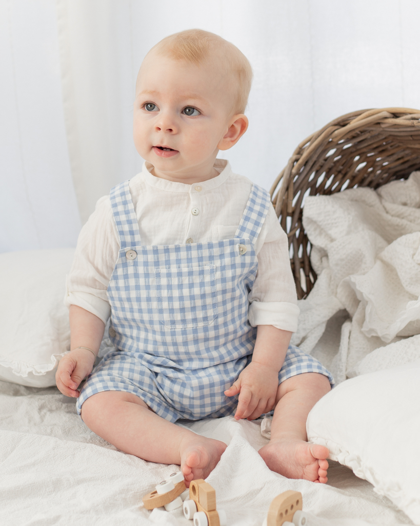 Dé-zoom du look composé d'une salopette pour bébé garçon à motif vichy avec une chemise en gaze de coton de la marque Bobine Paris.