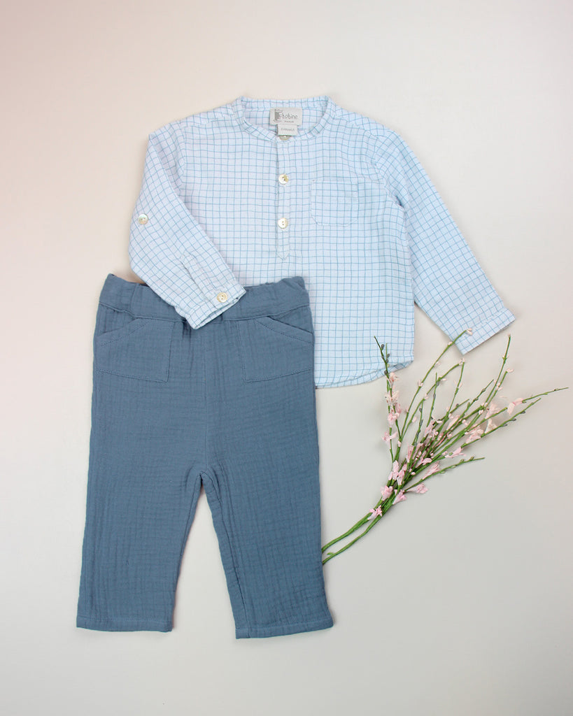 Look composé du pantalon en gaze de coton jean clair pour bébé et d'une chemise quadrillée bleue de la marque Bobine Paris.